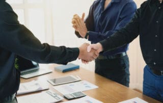 Businessman stand handshake and clapping of appreciation about the success of business at meeting.