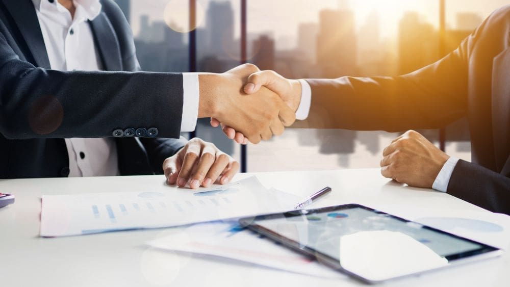 How Factoring Reduces the Need for Costly Short-Term Loans - Two men shaking hands